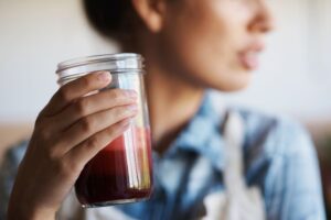 Mujer bebiendo un jugo détox rojo Vida Simple